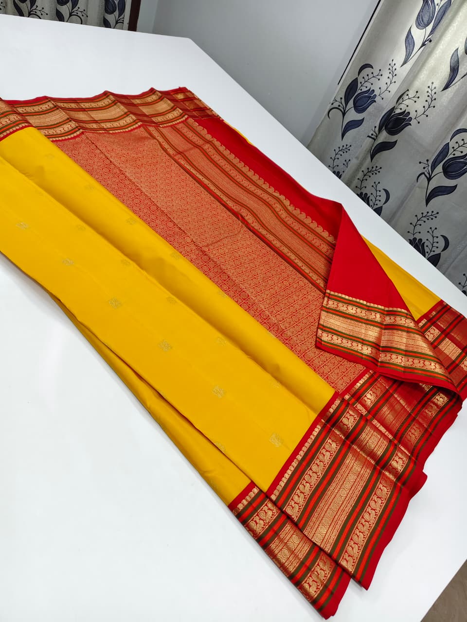 Handloom Kanchipuram Silk Saree with a traditional contrast border and buttas.